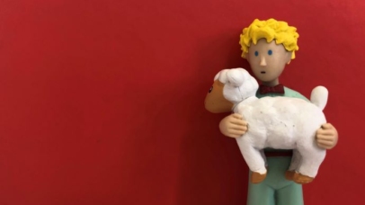 Fotografia de um boneco com uma ovelha ao colo.