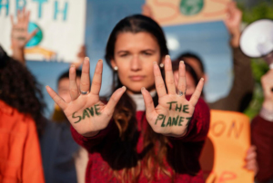 Imagem com uma pessoa que tem nas palmas das mãos escrito 'Save the planet'.