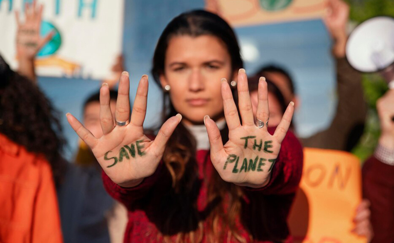 Imagem com uma pessoa que tem nas palmas das mãos escrito 'Save the planet'.