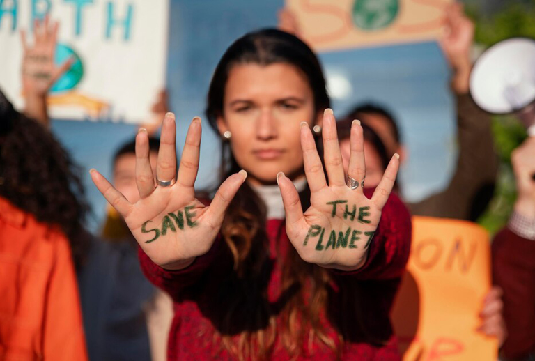 Imagem com uma pessoa que tem nas palmas das mãos escrito 'Save the planet'.