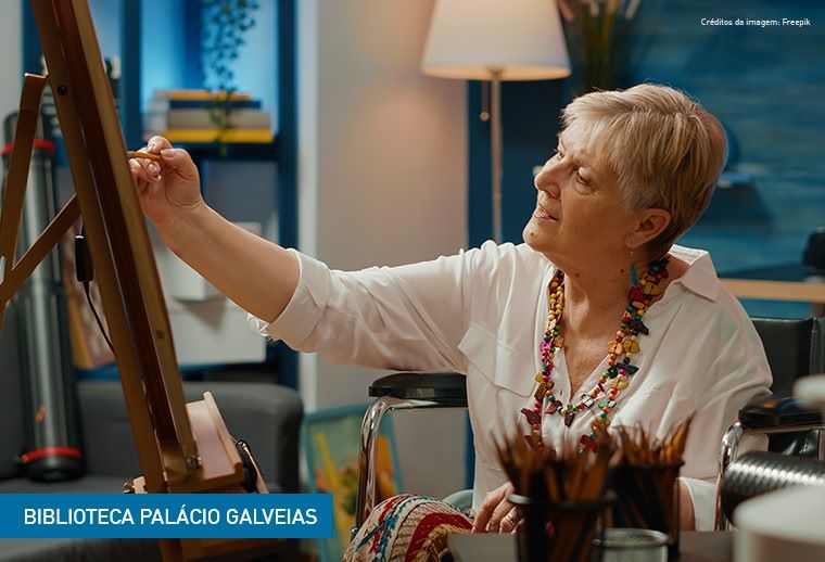 Imagem com uma pessoa adulta a pintar uma tela.