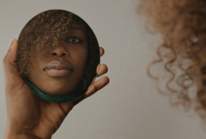 Imagem de uma mulher negra refletida num espelho.