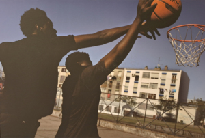 Imagem com duas pessoas a jogar basquetebol.