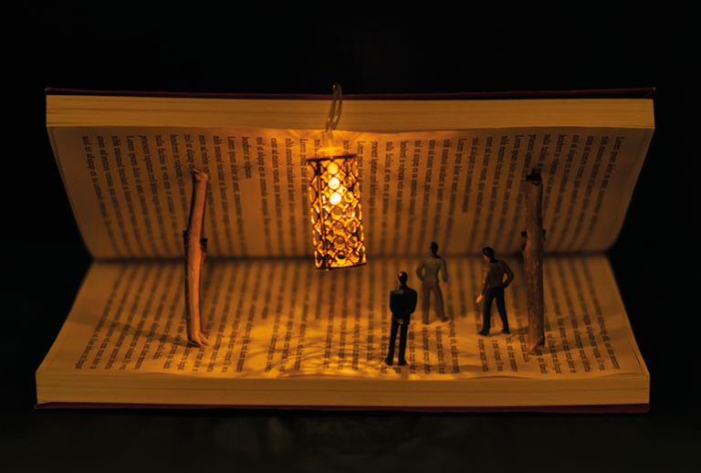 Imagem de um livro aberto com bonecos de pessoas no interior.
