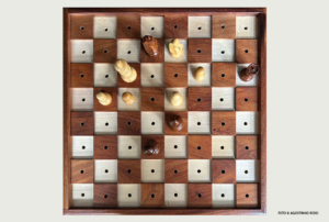 Imagem com um tabuleiro de xadrez com furos nas casas.